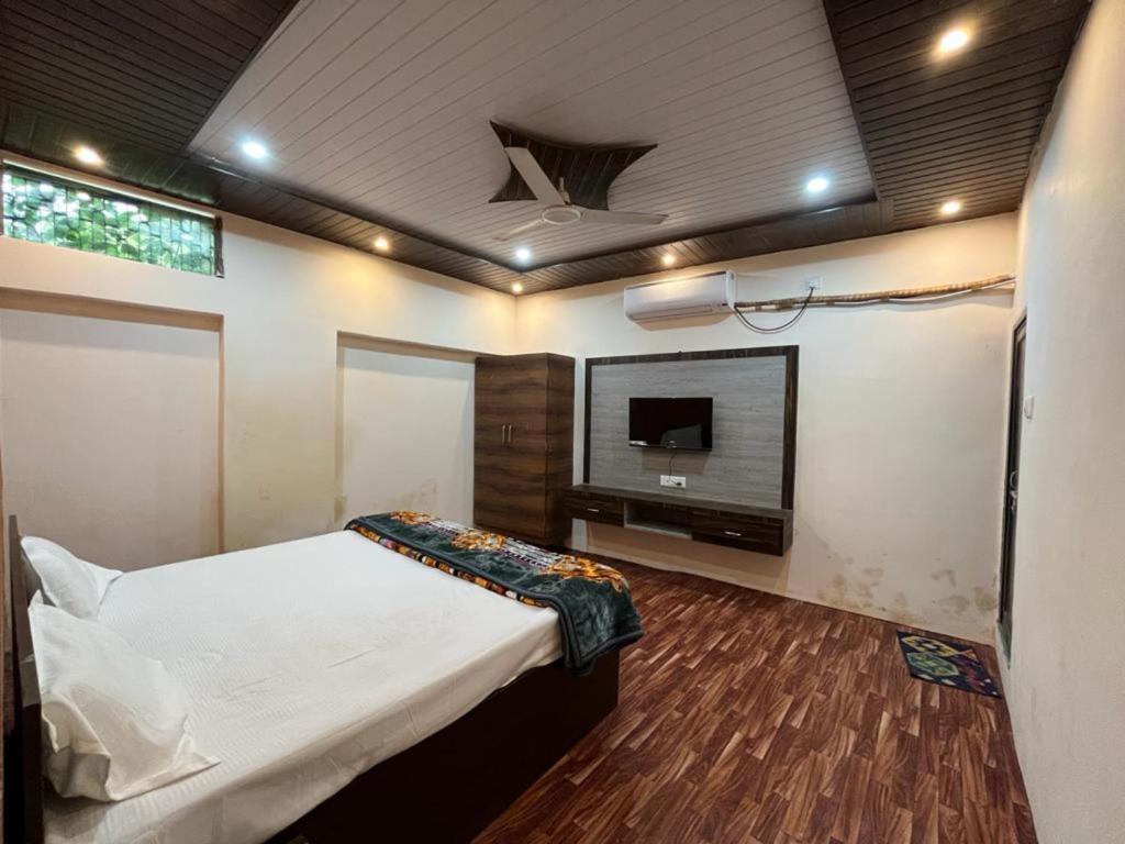 瓦拉纳西Hotel Varanasi Paradise - Best Seller - Parking facilities的一间卧室配有一张床和一台平面电视
