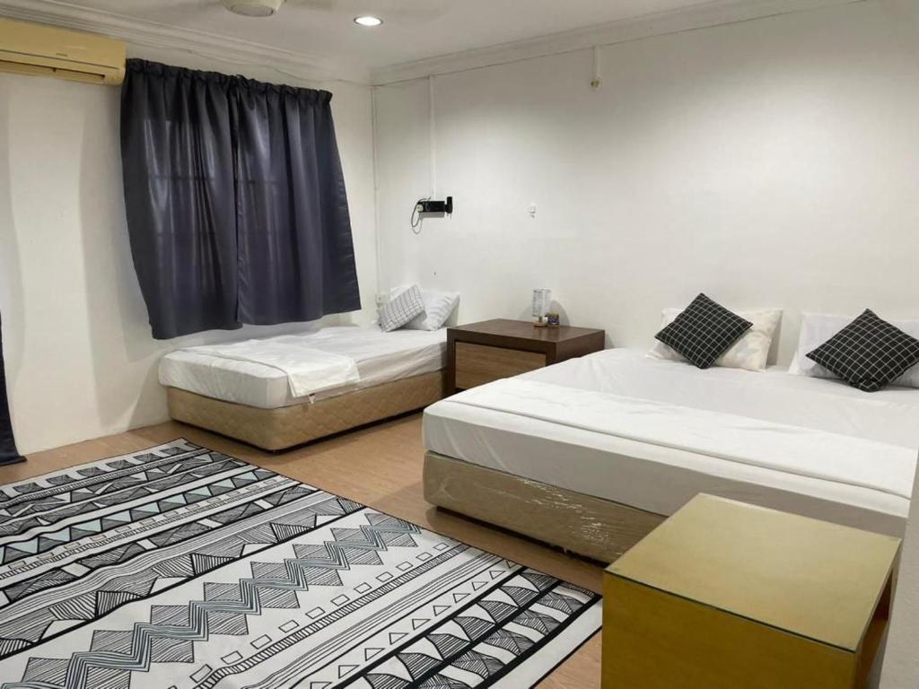 加央#KangaQHomestay99的一间卧室设有两张床、一张桌子和一个窗口
