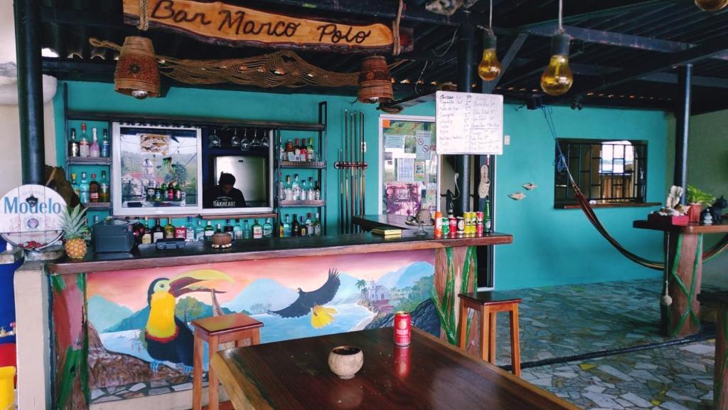 波托韦洛Hostal Portobelo的酒吧配有桌子和酒吧