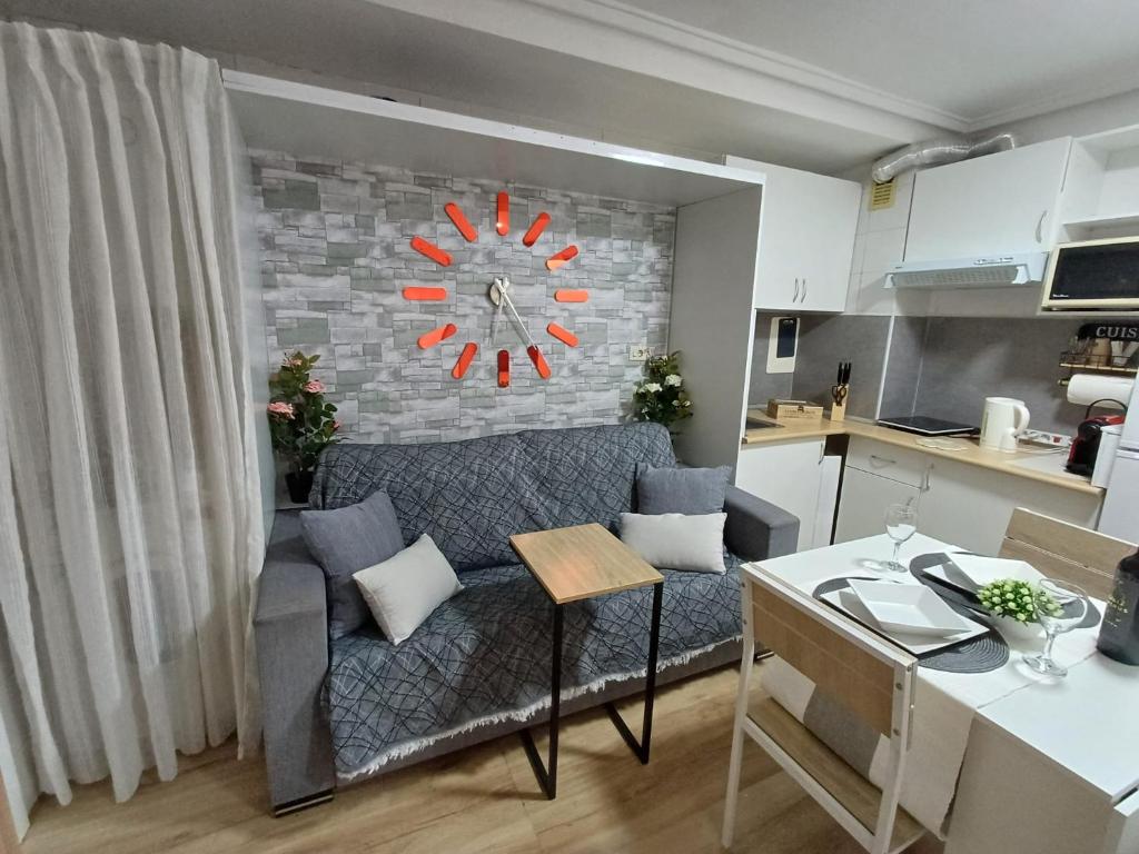 阿利坎特Alicante Denia Apartments的客厅配有沙发和墙上的时钟