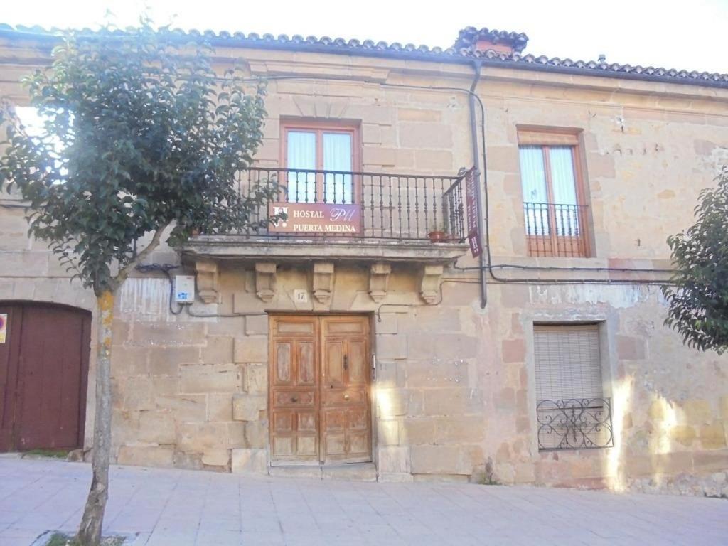 锡古恩萨VUT Casa de la Catedral Baja的石头建筑,设有木门和阳台