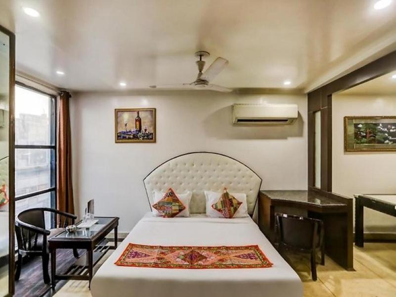 新德里HOTEL GEESON INTERNATIONAL-New Delhi Railway Station-Paharganj的一间卧室配有一张床、一张桌子和一张四柱床。