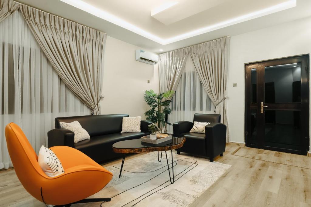 阿布贾Kashco Apartments Wuse 2 Abuja的客厅配有沙发、椅子和桌子