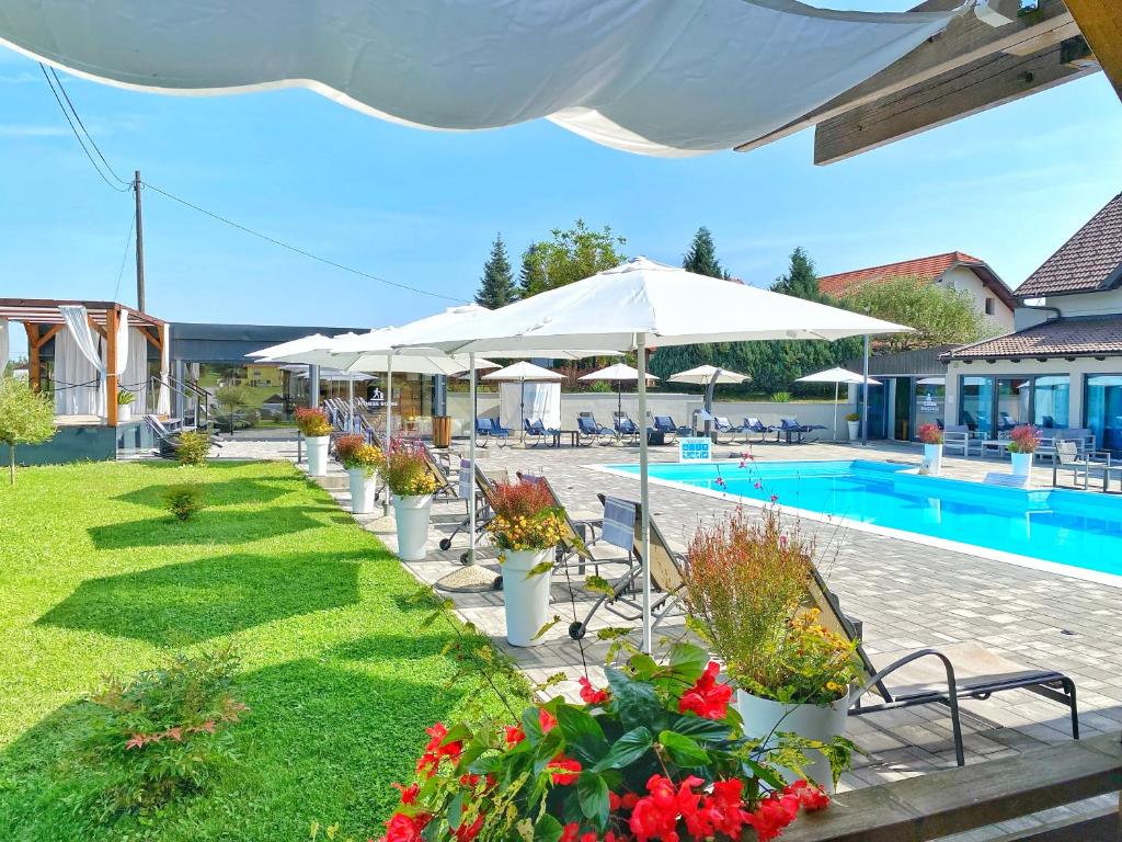 格拉博瓦茨16 Lakes Guesthouse的毗邻度假酒店的带椅子和遮阳伞的游泳池