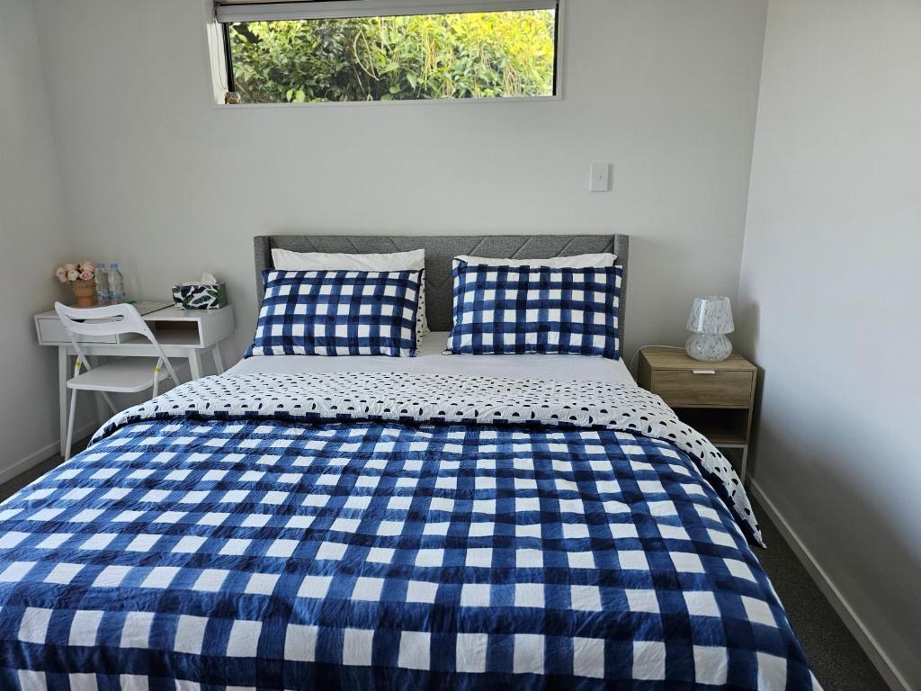 汉密尔顿Hillcrest Home的卧室里一张蓝色和白色的床,卧室里设有窗户