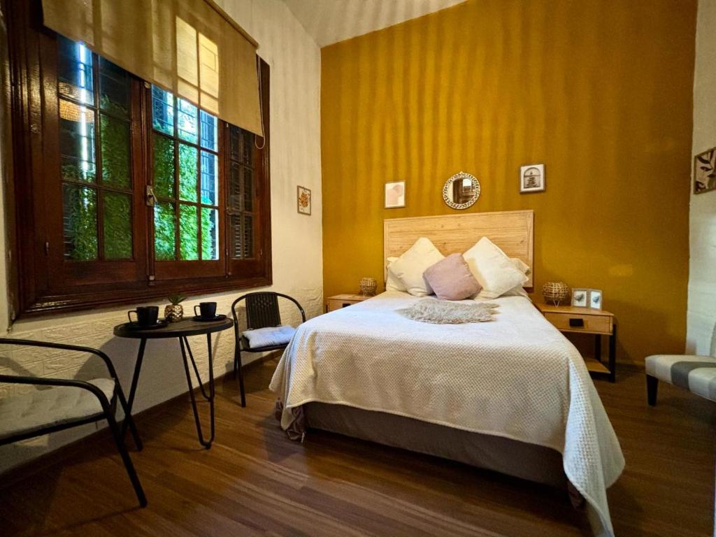 蒙得维的亚Expreso trescrucesdos的一间卧室设有一张床和黄色的墙壁