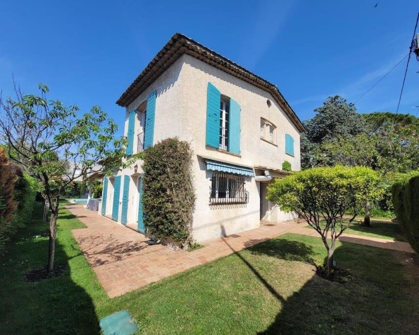 胡安莱潘Juan les pins : Villa de charme avec piscine的白色的大房子,设有蓝色百叶窗