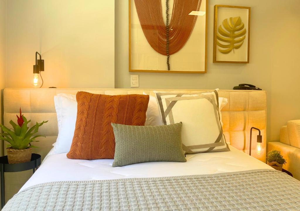 彼得罗波利斯Loft luxuoso na Serra - Granja Brasil Resort的卧室配有白色的床和枕头。