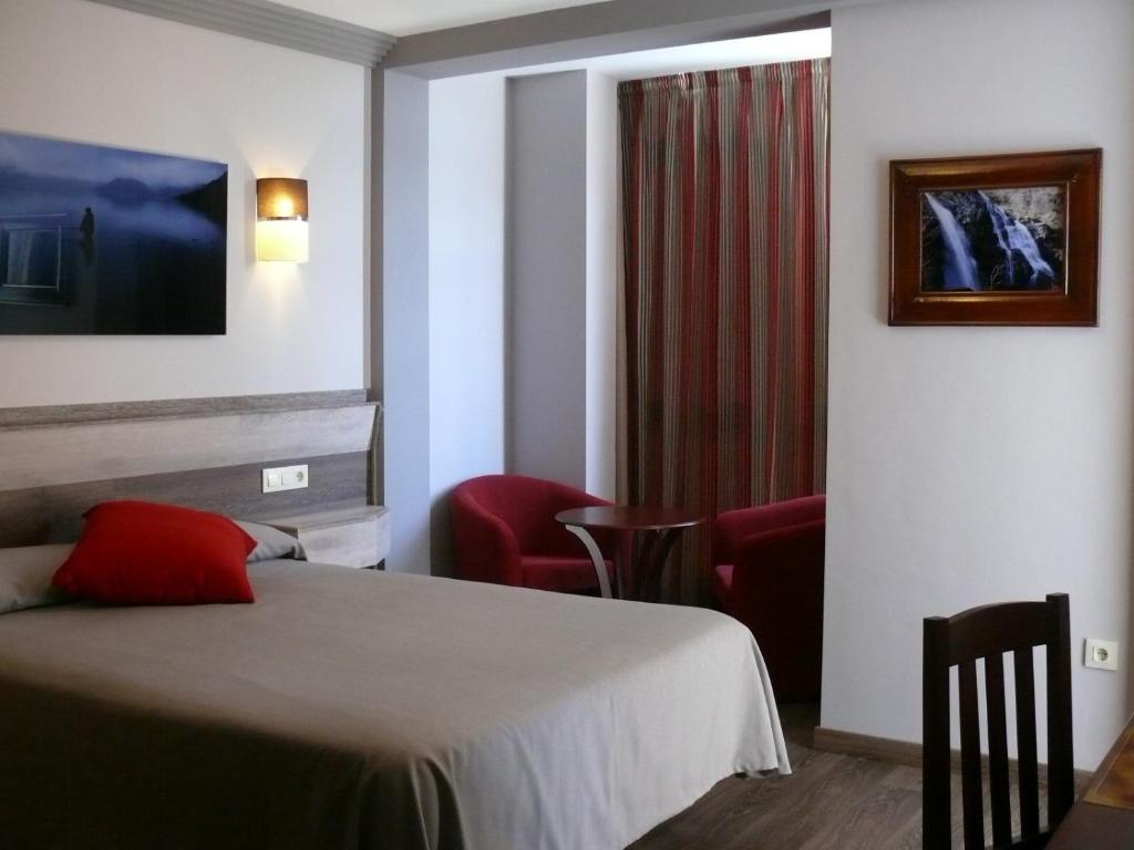 普韦布拉桑纳比亚Hotel Gran Casona de Sanabria的酒店客房,配有一张床和两把椅子