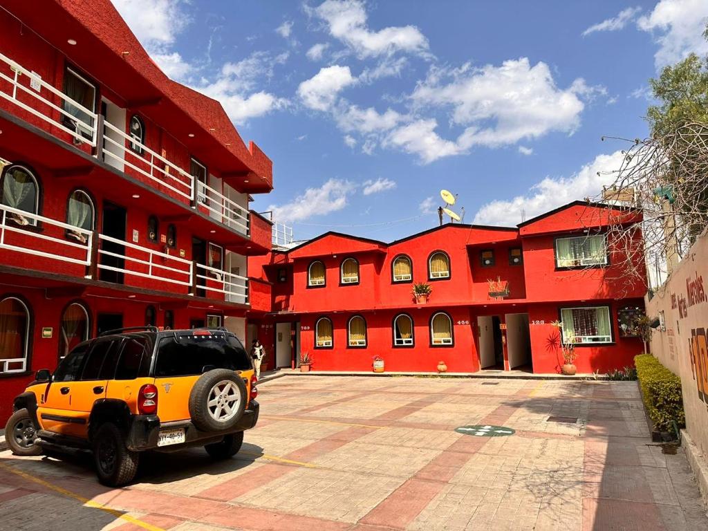 Santa Cruz TecamacPaléis的停在红色建筑前面的汽车