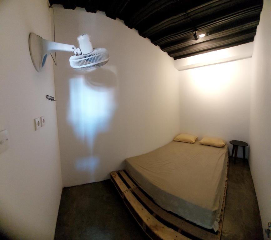 芝拉扎Cilacap Guest House的一间设有一张床的房间,墙上有灯