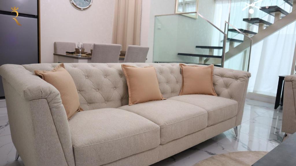 阿布扎比Chalet 2BR Duplex Apartment的客厅配有带枕头的沙发。