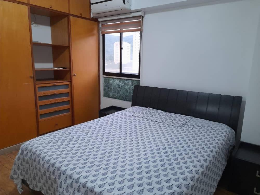 巴伦西亚Apartamento En Valencia的一间卧室配有一张床、一个衣柜和一个窗户。
