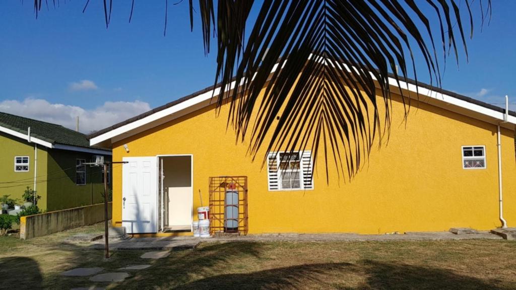 欧丘里欧LaMaison的一座黄色房子,前面有一棵棕榈树