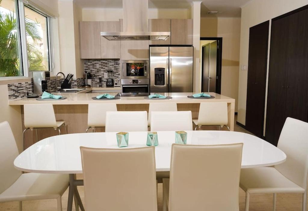 棕榈滩Spectacular apartment in levent eagle beach的厨房配有白色的桌子和白色的椅子