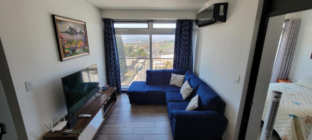 危地马拉Apartamento Parada 50的客厅配有蓝色的沙发和电视