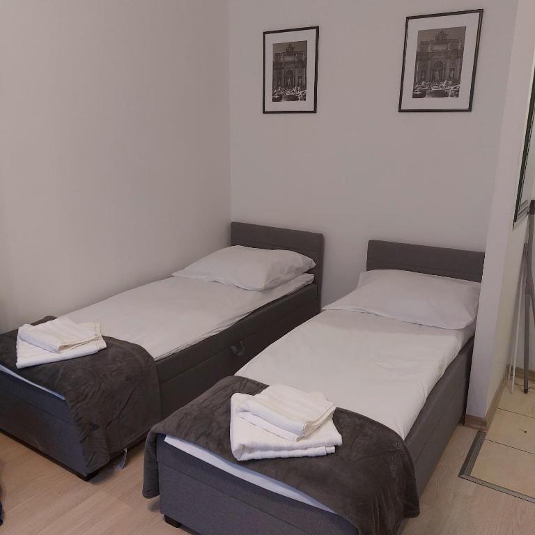 肯琴Apartament Mazurska的小客房内的两张床和毛巾