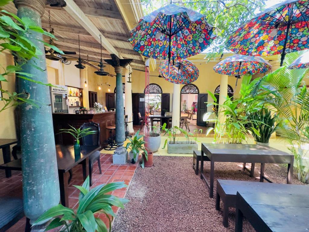 高尔Mango House - Galle Fort的餐厅内带桌子和遮阳伞的庭院