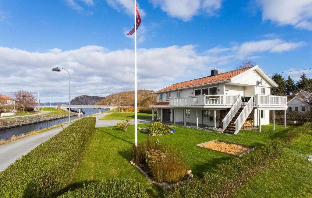SpangereidGorgeous Home In Lindesnes With Kitchen的草上有一根旗杆的白色房子