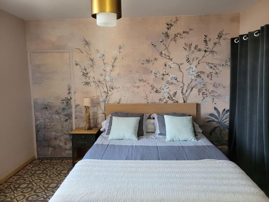 教皇新堡Maison de village panoramique的一间卧室设有一张床和鲜花墙