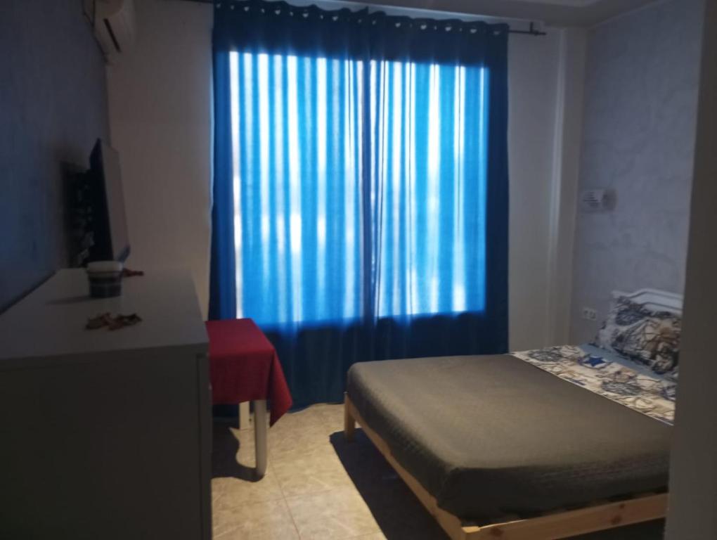 Hammamet SudVILLA BELLA VITA HAMMAMET的一间卧室配有床和蓝色窗帘