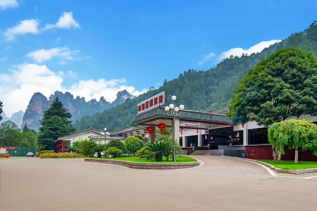 张家界Hunan New Pipaxi Hotel的山前的一座有树木的建筑