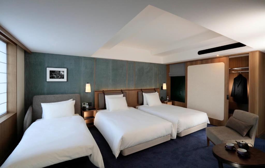 那霸嘉新酒店的酒店客房,配有两张床和椅子