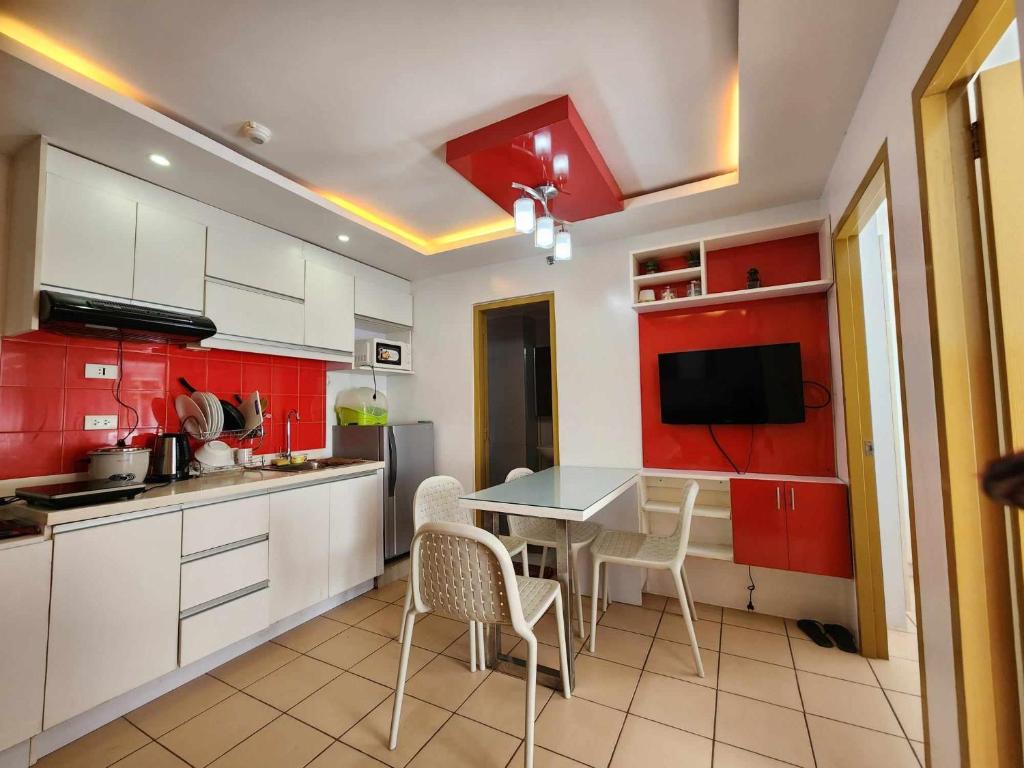 达沃市JFive Homes @ 8Spatial_B2的厨房配有红色橱柜和桌椅