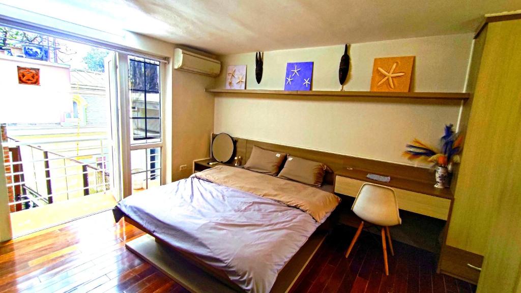 河内Gu.Inn的一间卧室配有一张床、一张书桌和一个窗户。