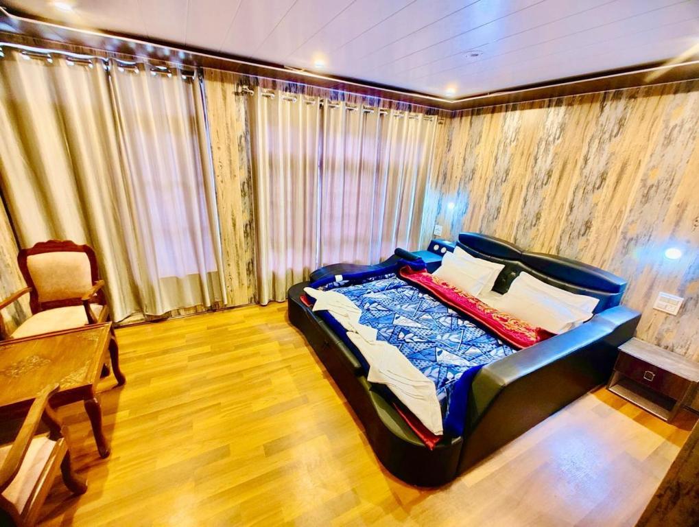 帕哈尔加姆Lady Pahalgam Resort Operated By Zaara Resorts的卧室配有1张床、1张桌子和1把椅子