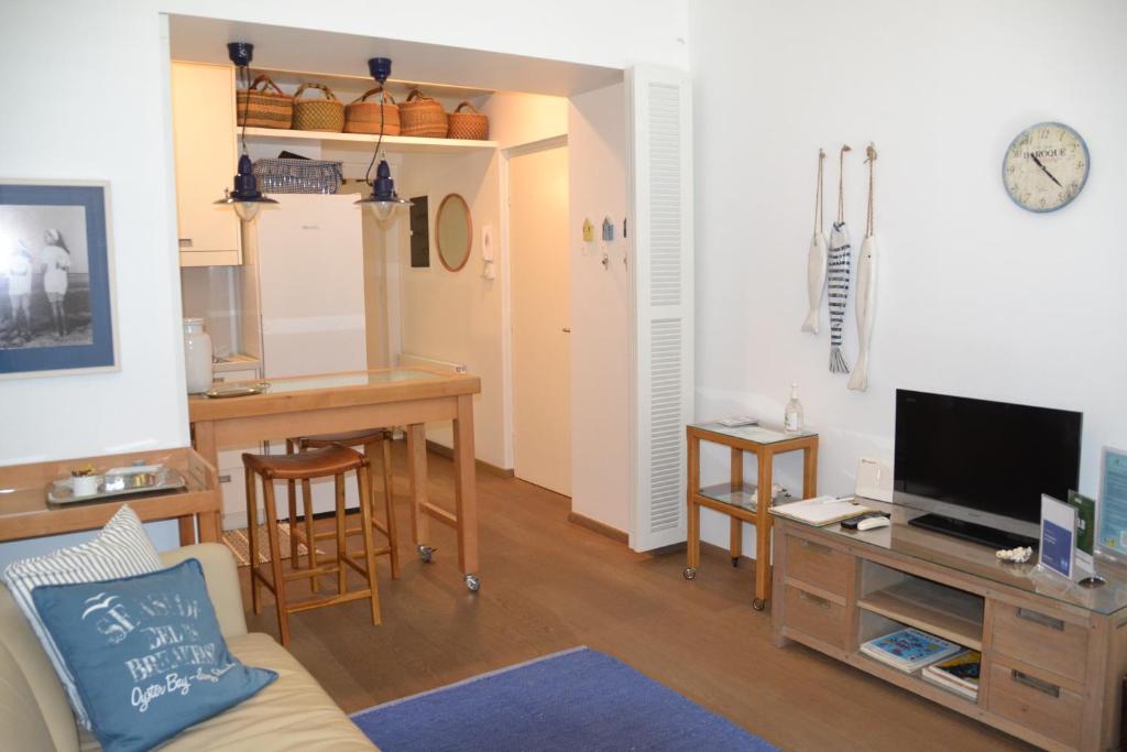 雅典Vouliagmeni seaside flat的客厅配有沙发和书桌及电视