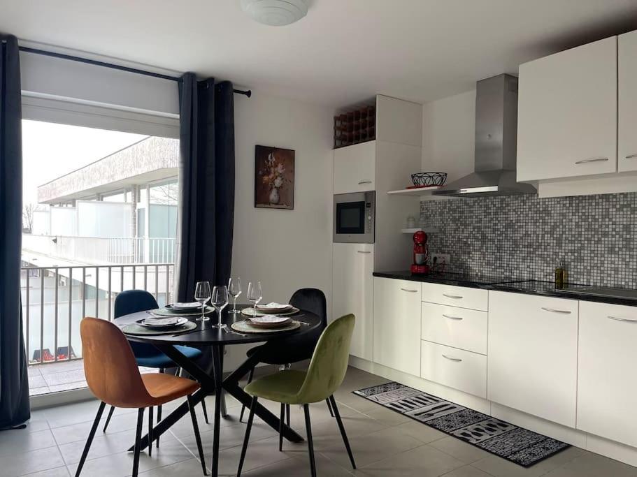 蒂尔特Appartamento ideal的带桌椅的厨房和带窗户的厨房