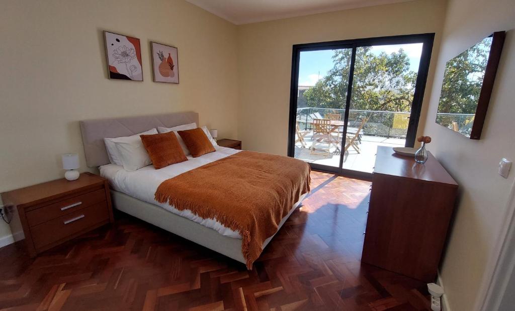 丰沙尔Villa Strelitzia的一间卧室设有一张床和一个大窗户