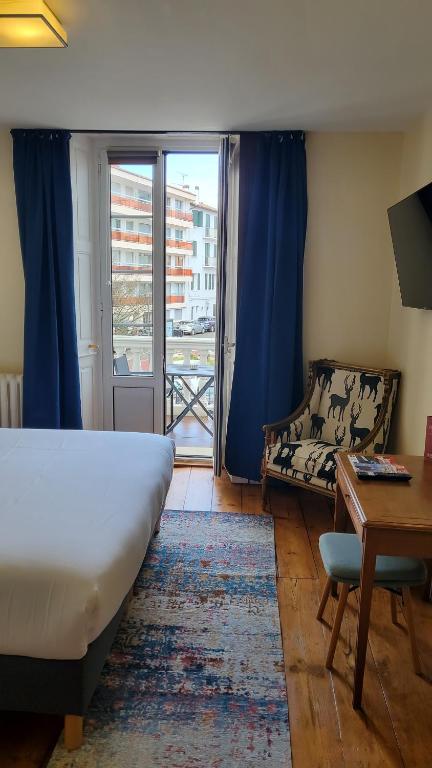 圣让-德吕兹德拉波斯特大酒店的一间卧室配有一张床、一张书桌和一个窗户。