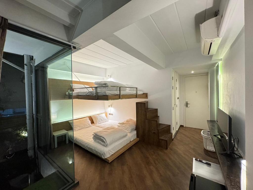 清迈One More Space的一间卧室设有双层床和玻璃墙