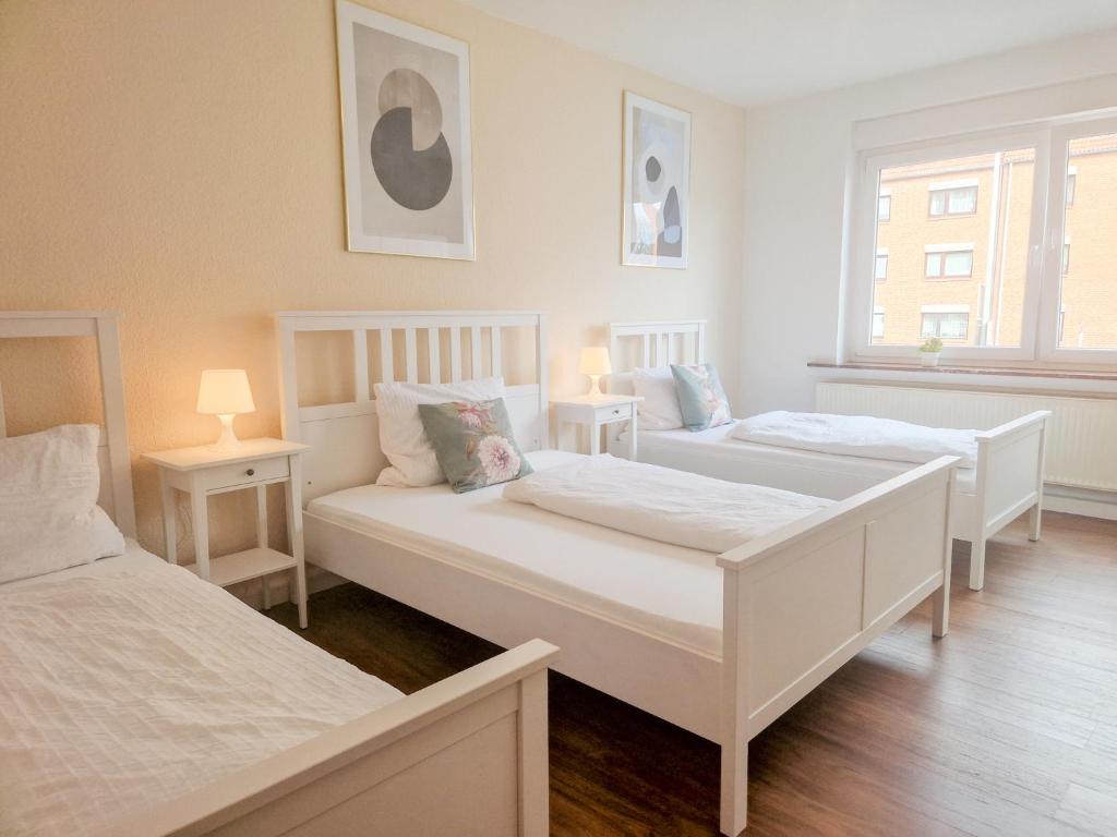 希尔德斯海姆Apartment am Dammtor的带2张桌子的客房内的2张白色床
