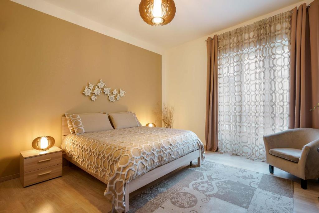圣安蒂奥科Montellinos Suite Tortora的卧室配有床、椅子和窗户。
