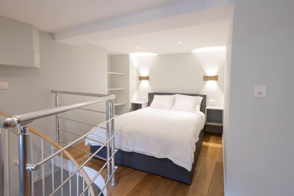 菲斯普Studio-duplex Tower的一间卧室配有一张带白色床单和两盏灯的床。