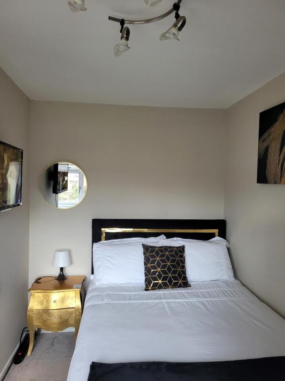ShevingtonNB's Cozy Nook的一间卧室配有一张白色的床和黑色床头板