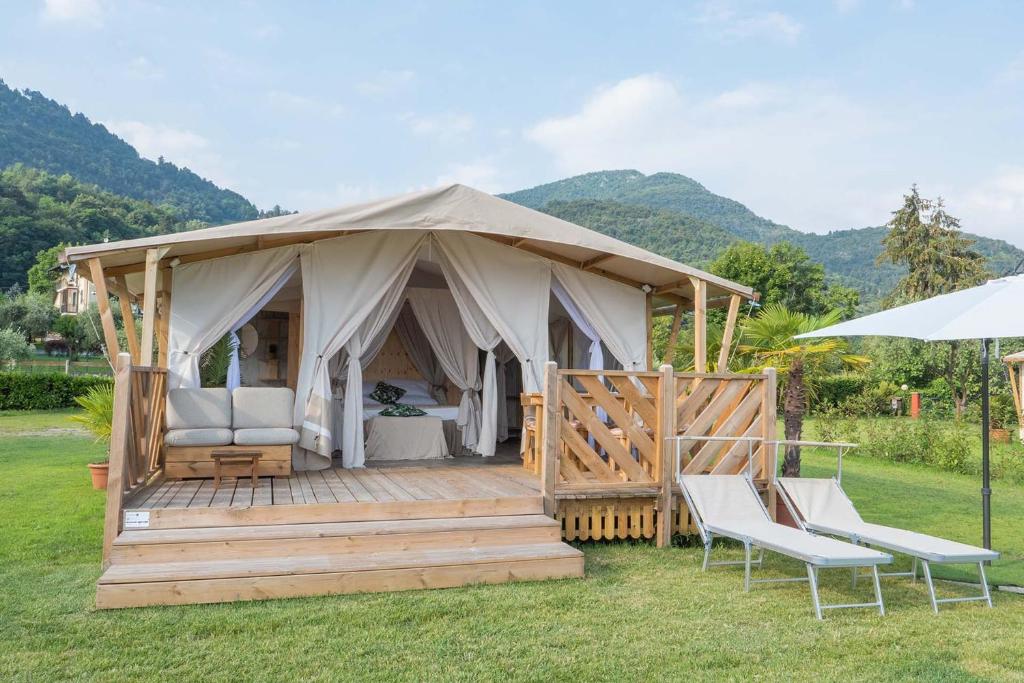 贝拉吉奥Luxury Lodge的一个带两把椅子和一把遮阳伞的豪华帐篷