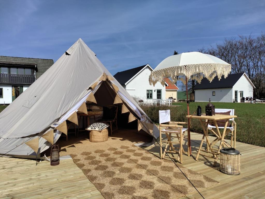 斯塔德Luxury Tent with Restroom and shower, close to the Beach的一个带桌子和雨伞的大型帐篷