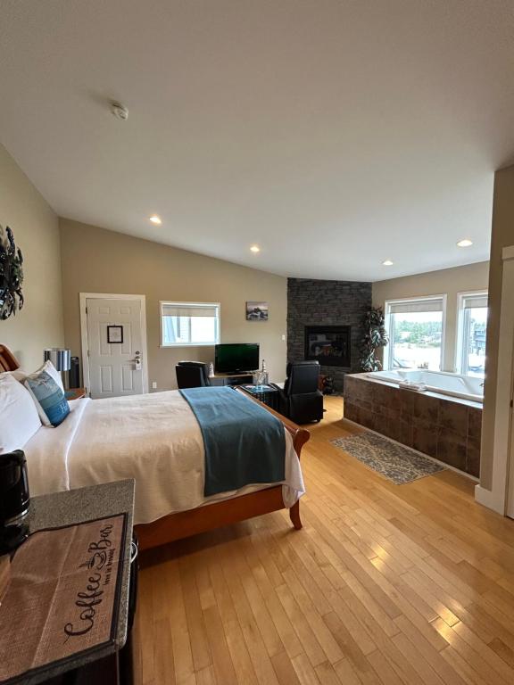 尤克卢利特Pacific Rim Guest Lodge - Adults Only的一间大卧室,配有一张大床和一个壁炉