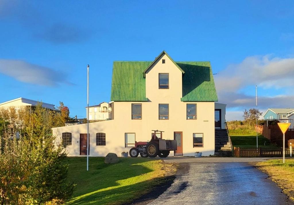 HríseyÁsgarður的一座带绿色屋顶的大型白色房屋