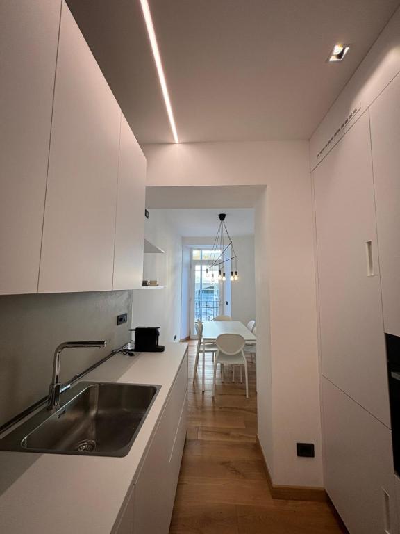 多莫多索拉Residenza la Torretta的厨房配有白色橱柜、水槽和桌子