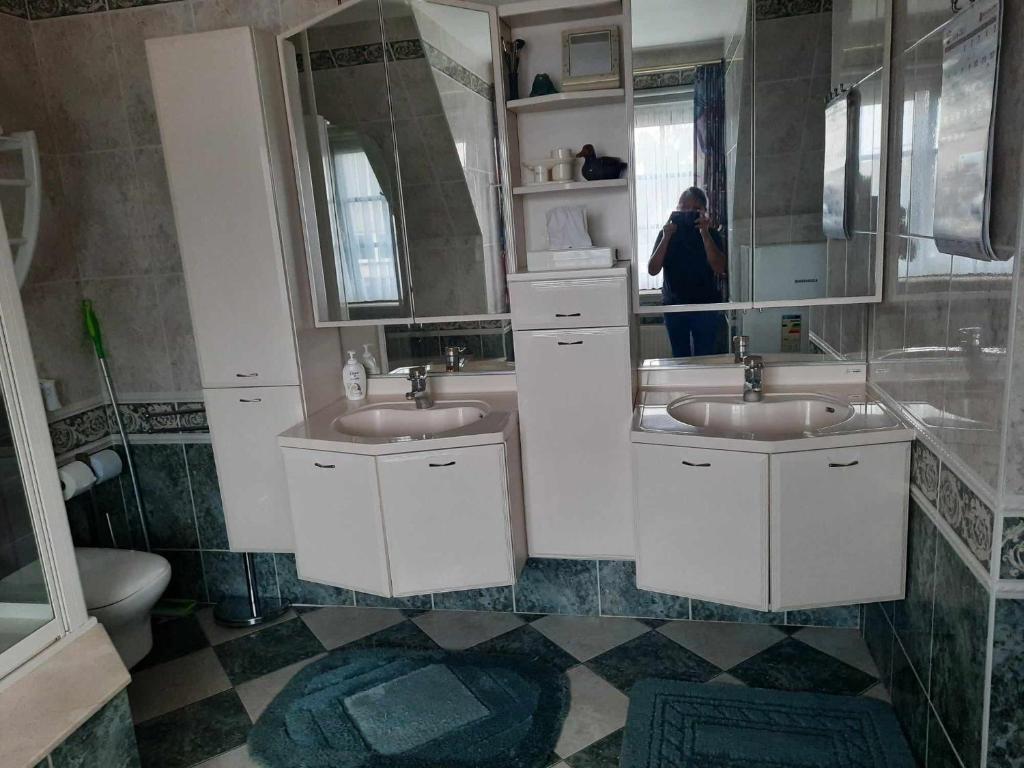 克诺克－海斯特Logies的一位女性拍着一个浴室的图片,浴室里有两个水槽