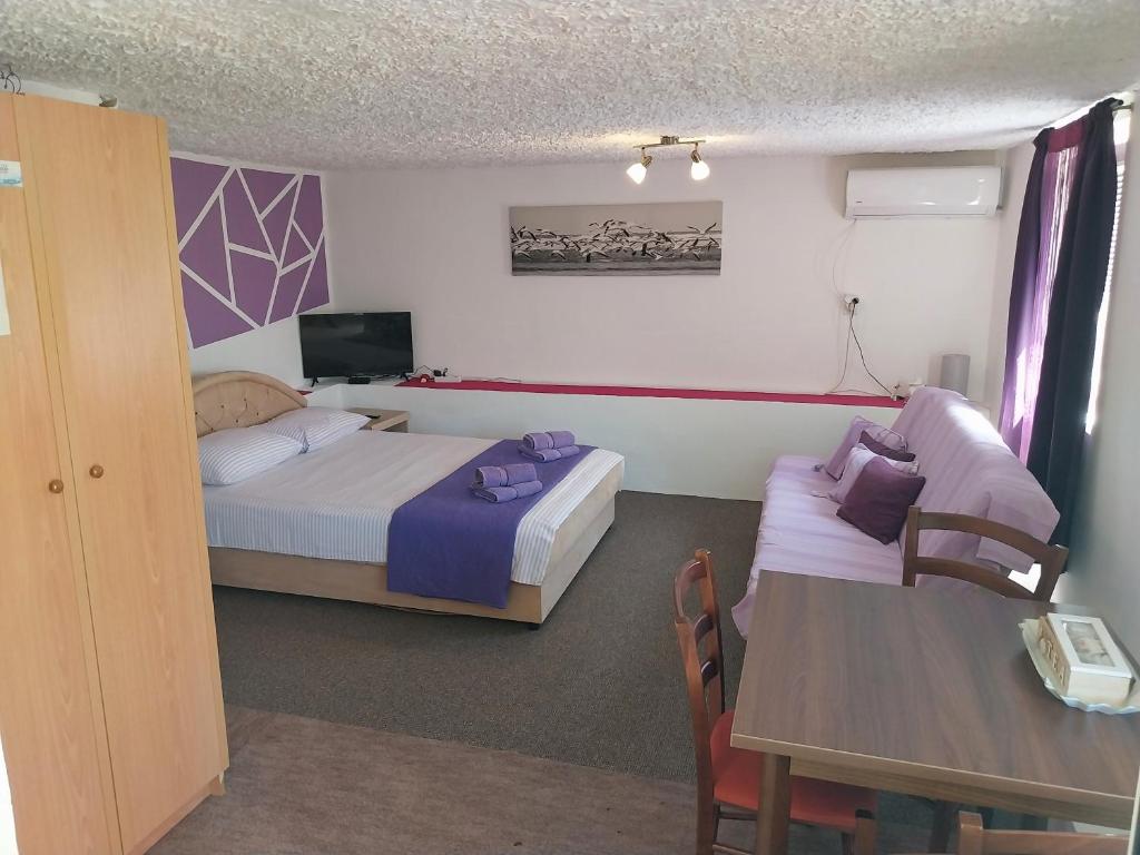 蒂瓦特Petkovic Apartmani 2的酒店客房设有两张床、一张桌子和电视。