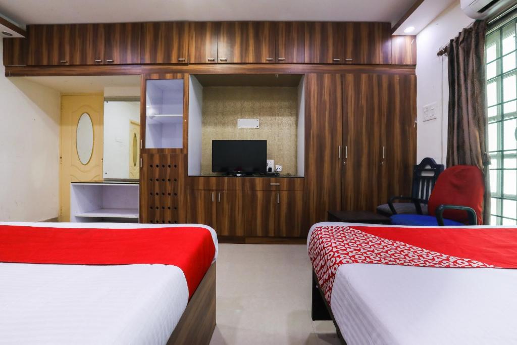 钦奈OYO Flagship Maheshwari Villas的酒店客房设有两张床和电视。