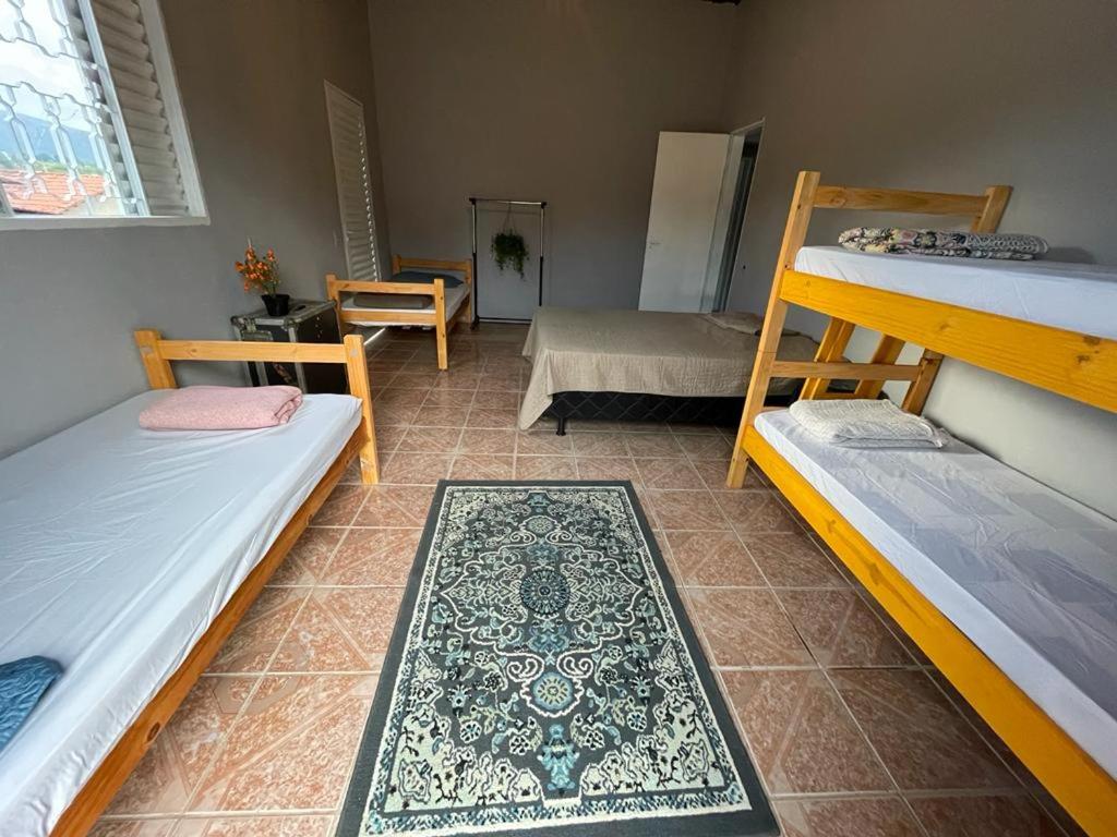 卡瓦坎特Hostel do Cerrado的客房设有三张双层床和一张桌子。
