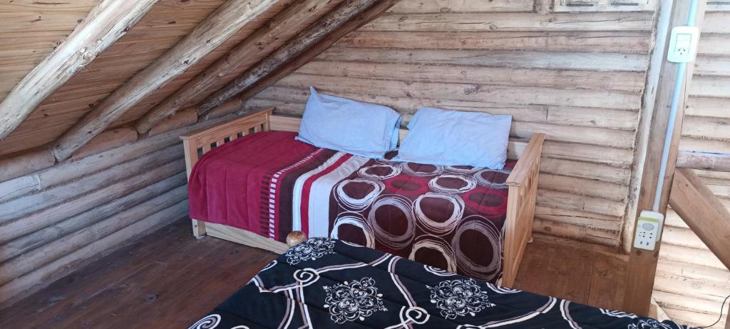 波特雷里约斯Cabaña Rincón del Sol的小木屋内一间卧室,配有一张床