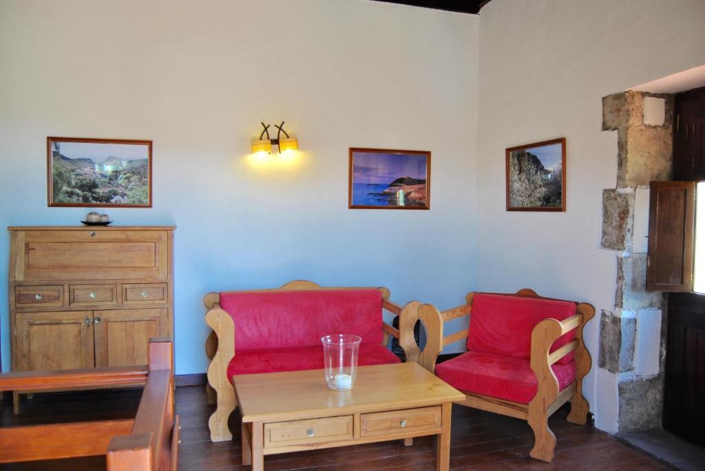 阿古伊梅斯埃尔格拉内罗乡村民宿的客厅配有2把红色椅子和桌子